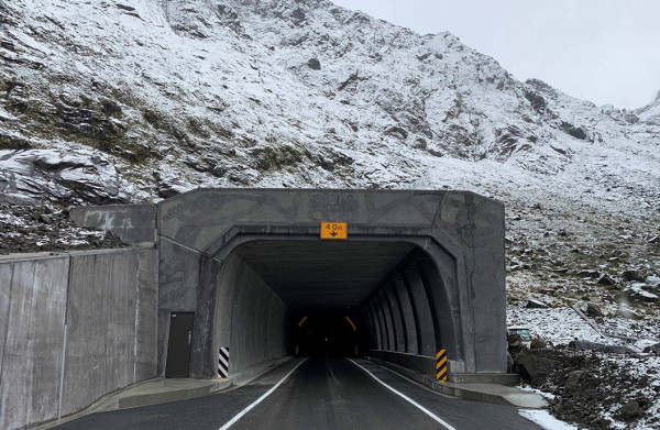 Looking into the tunnel from outside with snow on the hillside.