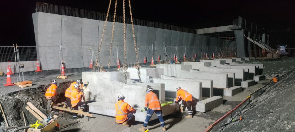 Work crew installing concrete blocks at night.