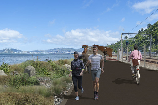 People walking and cycling on shared path with Wellington Harbour to the left and rail on the right.