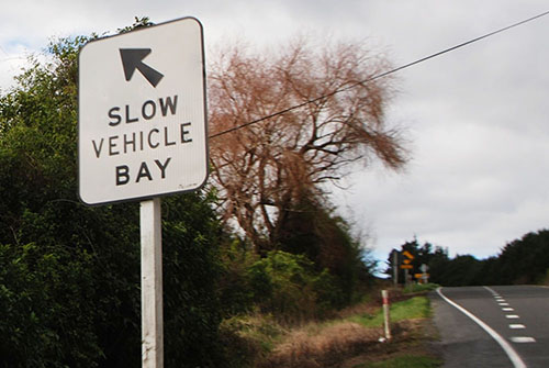 Slow vehicle bay road sign.